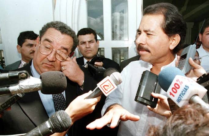 Daniel Ortega y Arnoldo Alemán rodeados de micrófonos de prensa