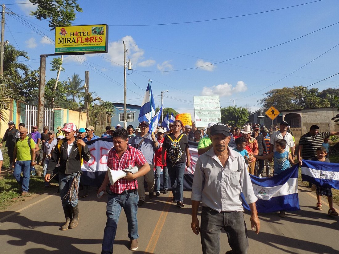 Campesinos marchan en la carretera de Nueva Guinea hacia Managua con pancartas contra la represión