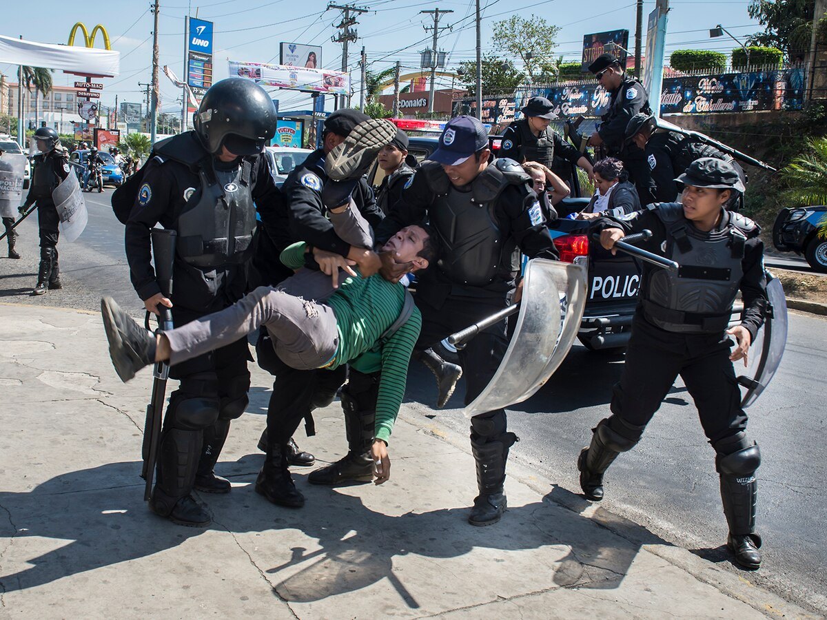 Policías antidisturbios cargan a una persona