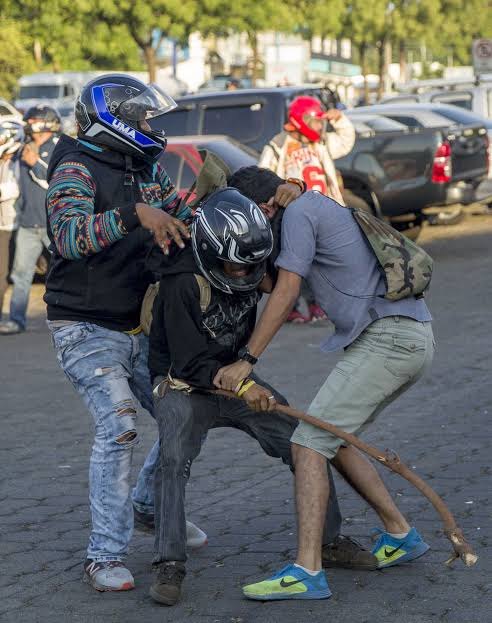 Hombres encapuchados sujetan a otro en la calle