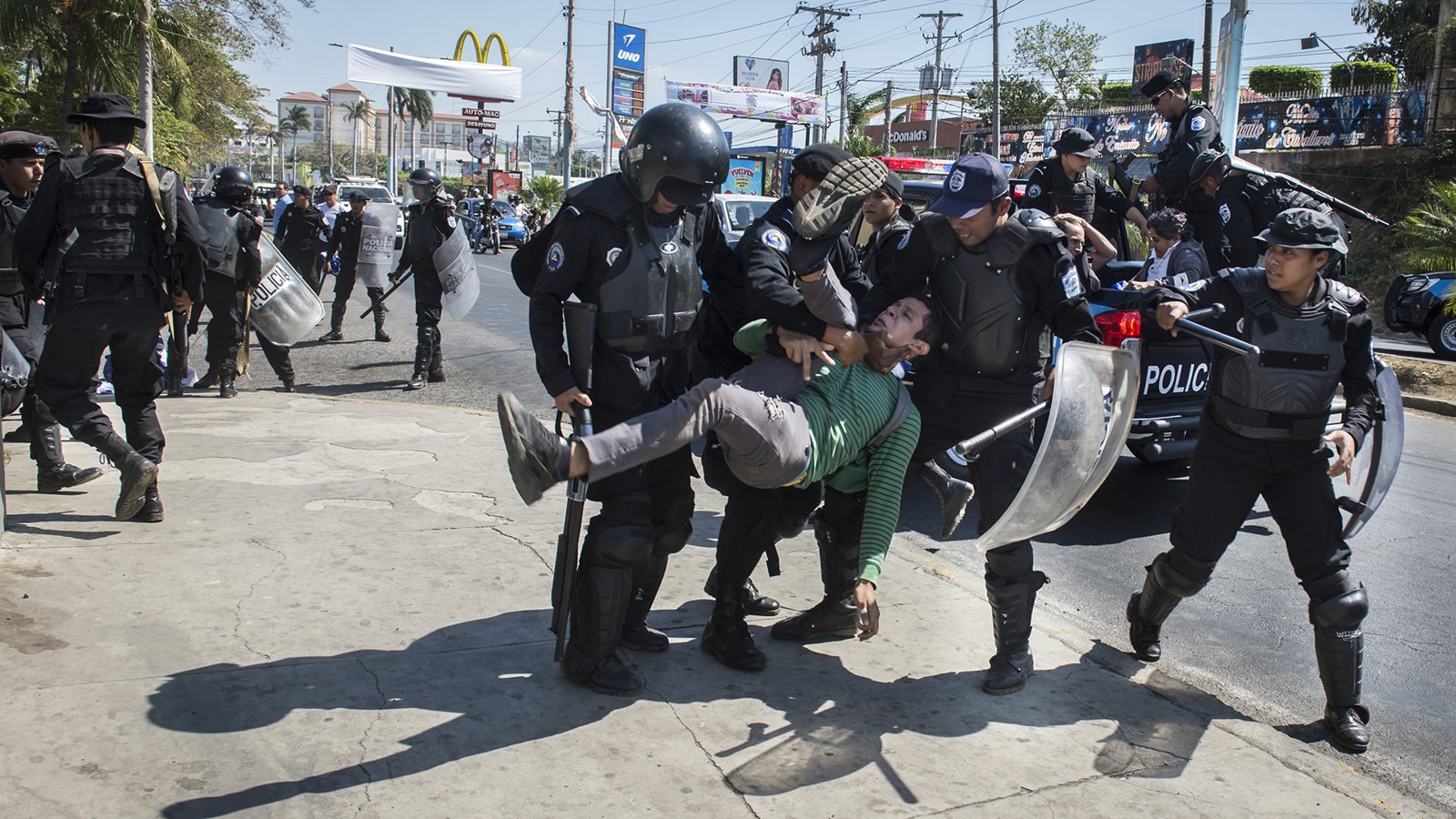 Policías antidisturbios cargan a un hombre