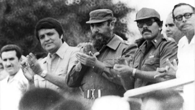 Fidel Castro entre dirigentes sandinistas que aplauden