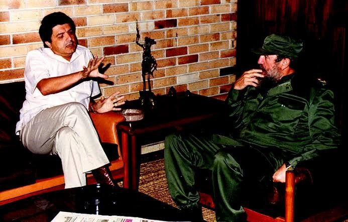 Fidel Castro conversa con un hombre de camisa blanca